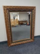 A contemporary bevel edged mirror in green and gilt frame.