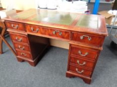 A reproduction mahogany twin pedestal desk fitted with nine drawers and three leather inset panels
