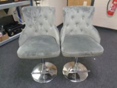 A pair of contemporary button back gas lift breakfast bar chairs upholstered in a suede style