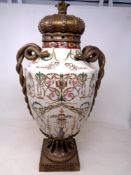 A decorative gilt metal and crackle glazed ceramic lidded vase with snake handles