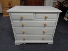 A painted two over three chest of drawers with pine handles.