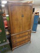 A 20th century walnut veneered two door cabinet with three drawers fitted beneath