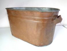 An oval copper twin handled tub (width 57cm).