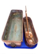 Two copper troughs, one on lion paw feet together with two antique copper ladles.