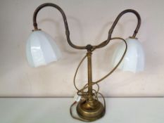 An Edwardian brass two way desk lamp with opaque glass shades.