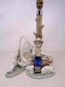 A Nao figural table lamp, seated boy, together with a further Nao figure group of geese.