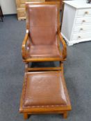 A reproduction leather upholstered scroll arm armchair with footstool.