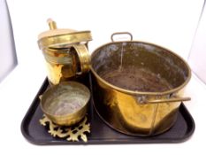 A tray containing brass ware including an oval twin handled pot, a watering can, a trivet,