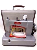 A vintage Essex miniature sewing machine with instructions in case.
