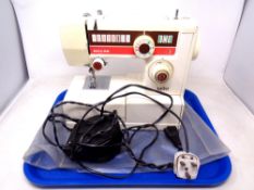 An Riccar mini electric sewing machine with foot pedal and cover