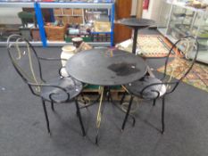 A circular Art Deco style patio table together with two armchairs.