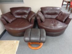 A pair of Burgundy leather swivel cuddle chairs with cushions together with a further leather