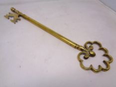 An ornamental brass oversized key (length 47cm).