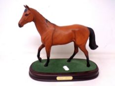 A Royal Doulton figure of Red Rum mounted on a plinth.