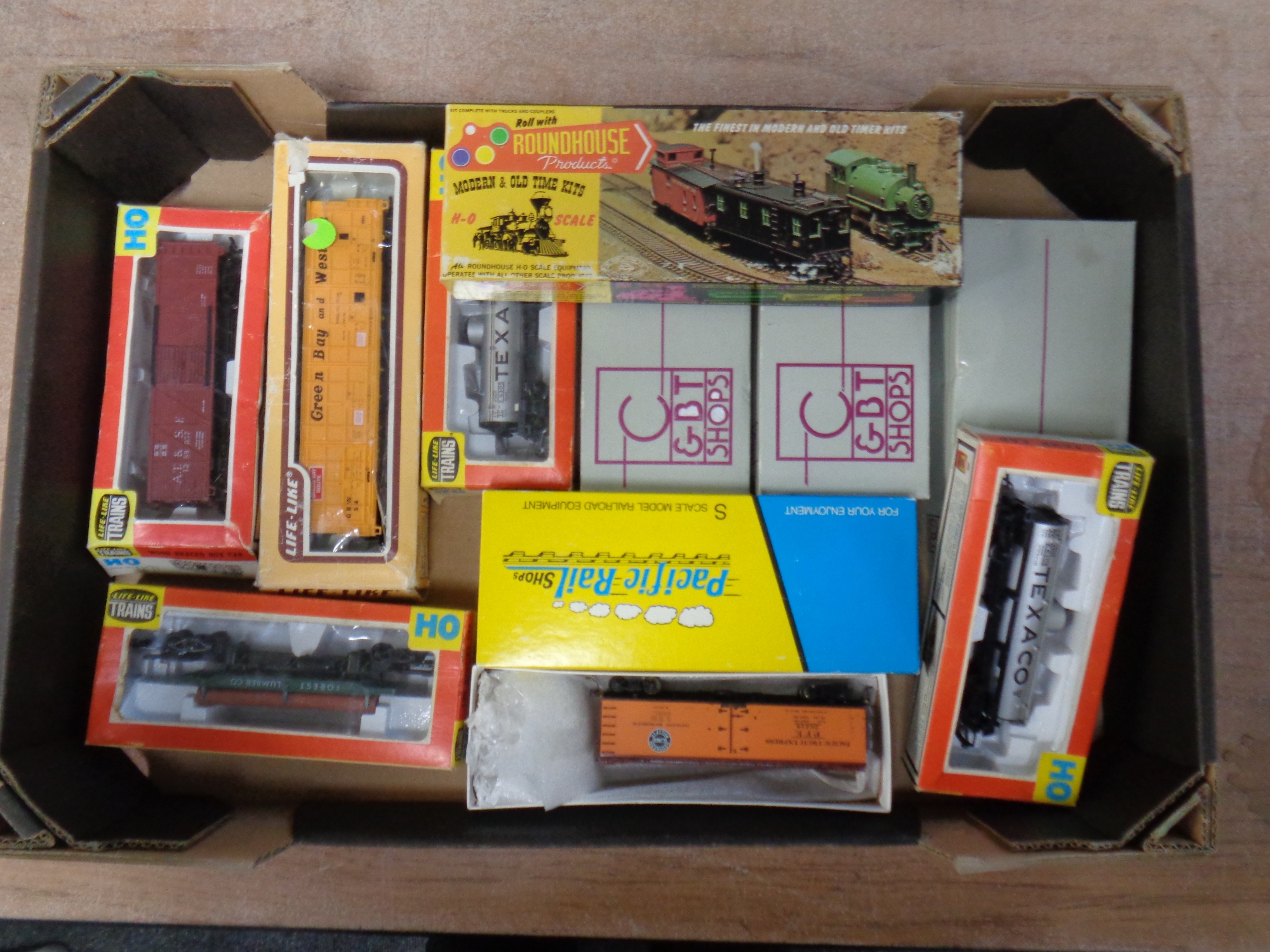 A box containing Roundhouse Lifelike trains and Heritage collection rolling stock,