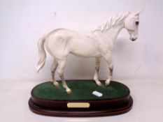 A Royal Doulton figure of Desert Orchid mounted on a plinth.