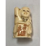 A carved bone Chinese netsuke - Gentleman carrying a scroll