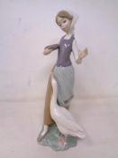 A Lladro figure of a girl feeding geese.