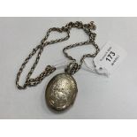 An antique white metal locket on long guard chain