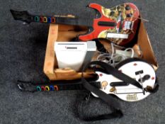 A box containing a Nintendo Wii with leads together with two Guitar Hero guitars with controllers.