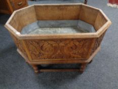 An octagonal carved oak and metal-lined planter on stand.