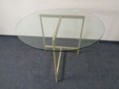 A circular glass topped table on metal base.