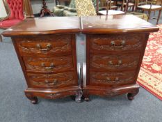 A pair of carved mahogany bow fronted three drawer bedside chests.