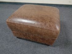 A brown leather storage footstool.
