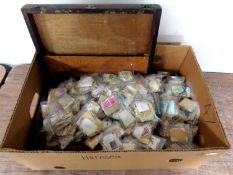 A wooden artist's box containing hundreds of loose stamps.