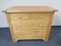 A contemporary two-over-two four drawer chest in a pine finish.