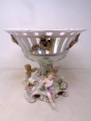 A continental china comport on a cherub flower encrusted base (height 23.5cm).