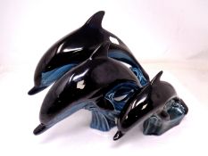 A graduated set of three Poole dolphins (tallest 18cm).