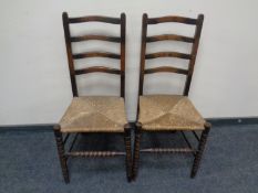 A pair of Edwardian ladder back rush seated chairs.