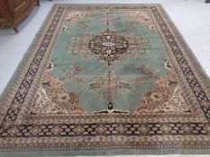 A machined carpet with central medallion on green ground,