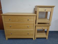 A contemporary three drawer chest together with a pair of matching bedside stands in an oak finish.
