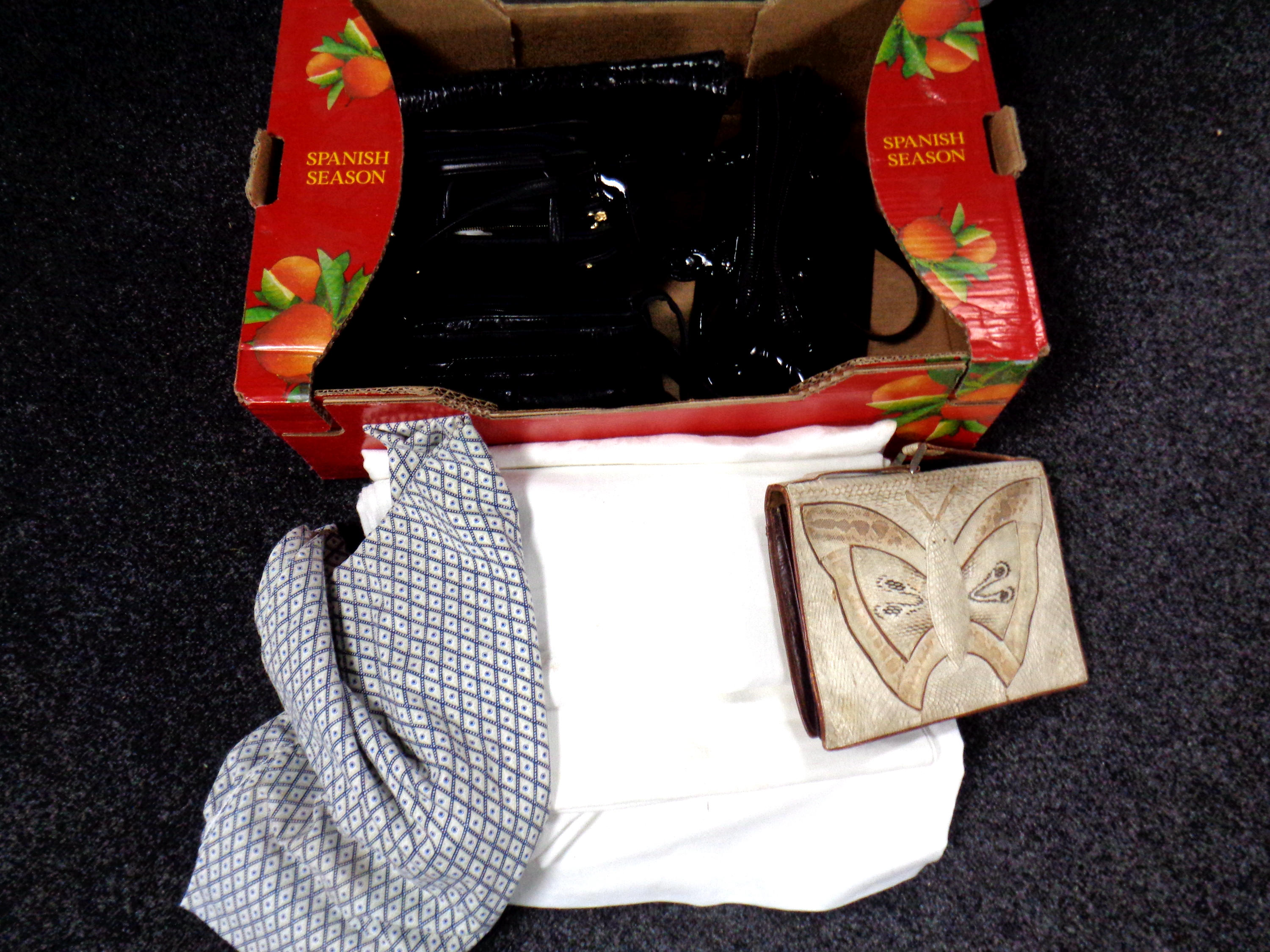 A box of lady's handbags and table linen.