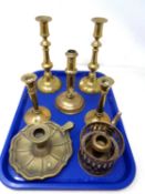 A tray containing brass candlesticks including a rise and fall example.