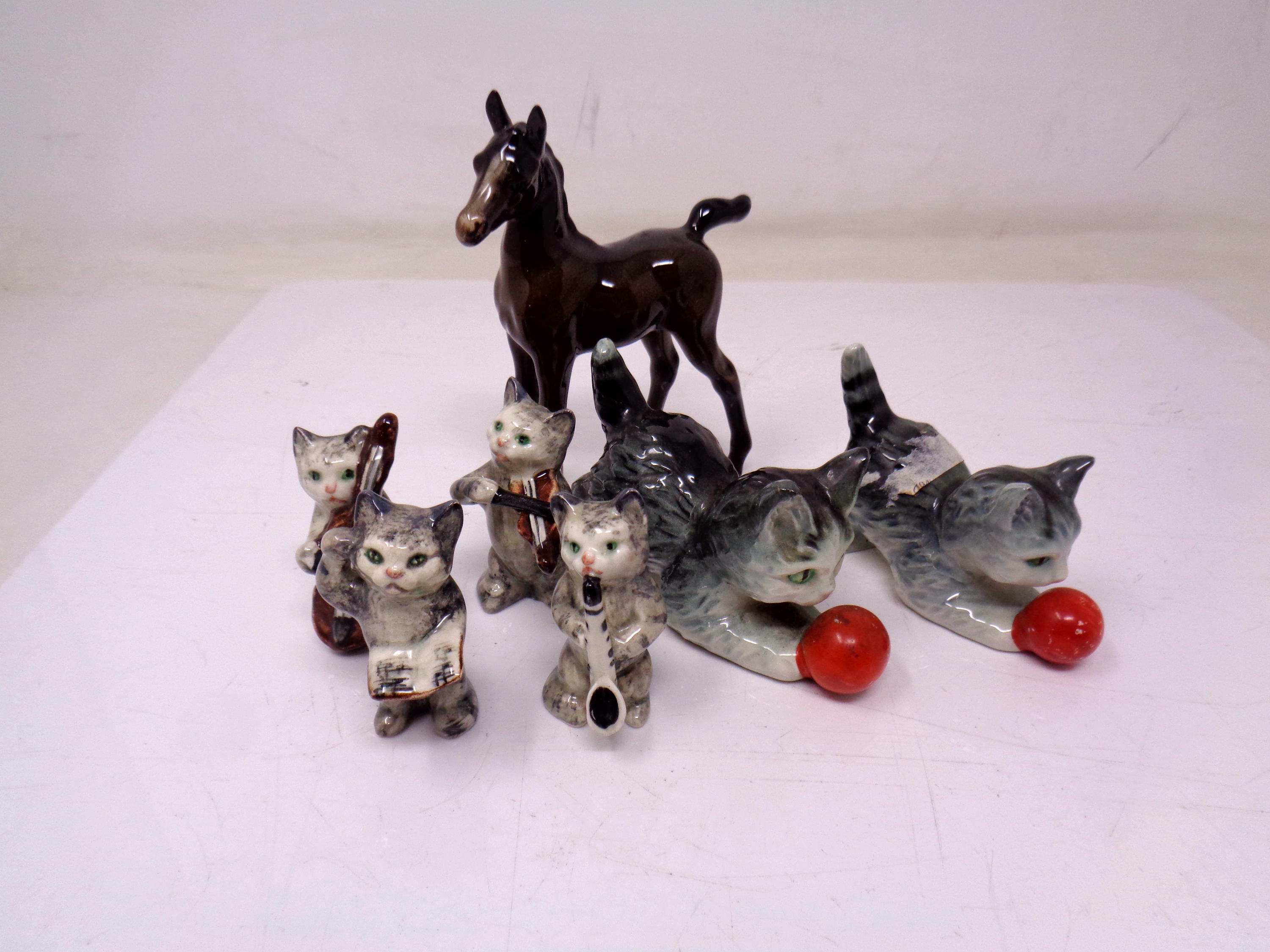 A Beswick figure of a foal together with a cat musician group and two further cat figures.