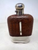 A glass hip flask with silver and leather mounts.