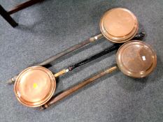 Three antique copper-headed bed warming pans.