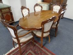 A shaped Italian style pedestal dining table with a set of six matching chairs,