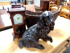 A wicker twin handle basket together with a dog ornament and a mantel clock.