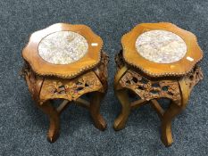 A pair of carved pine Chinese plant stands with marble inset tops.