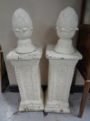 A pair of concrete classical pedestals with finials (painted).