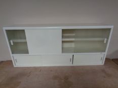 A mid 20th century painted sliding door wall mounted kitchen cupboard.