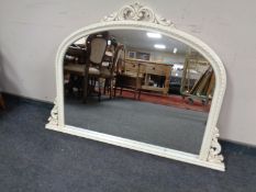 A cream framed arched overmantel mirror.