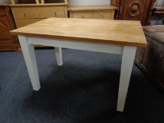 A pine kitchen table on painted legs (length 122cm).