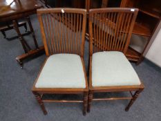 A pair of Edwardian oak rail back chairs.