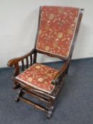 An Edwardian rocking chair upholstered in floral fabric.