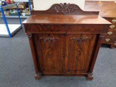 A Victorian mahogany double door cabinet fitted with drawers above and pillar column supports.
